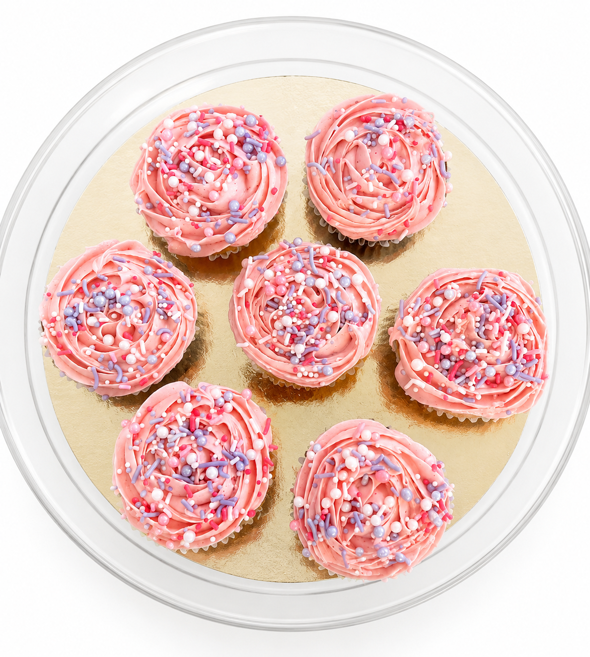 Pink frosted cupcakes with colorful sprinkles on a white cake stand