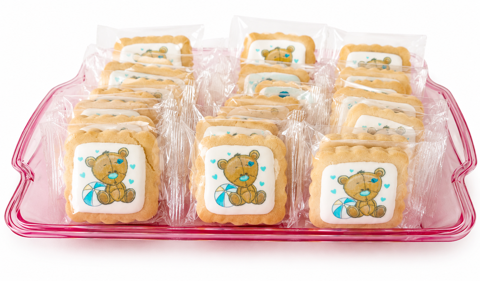 Individually wrapped shortbread cookies with teddy bear and umbrella designs on a pink tray
